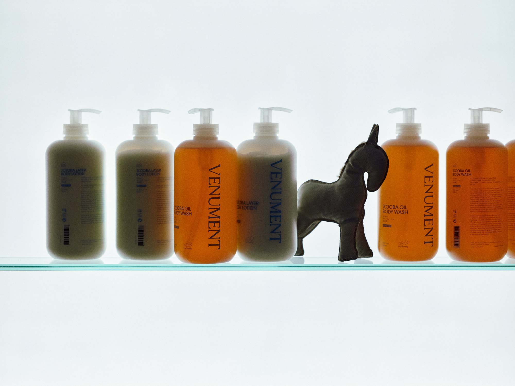VENUMENT body care on the backlit lightbox shelf — flagship store 2024